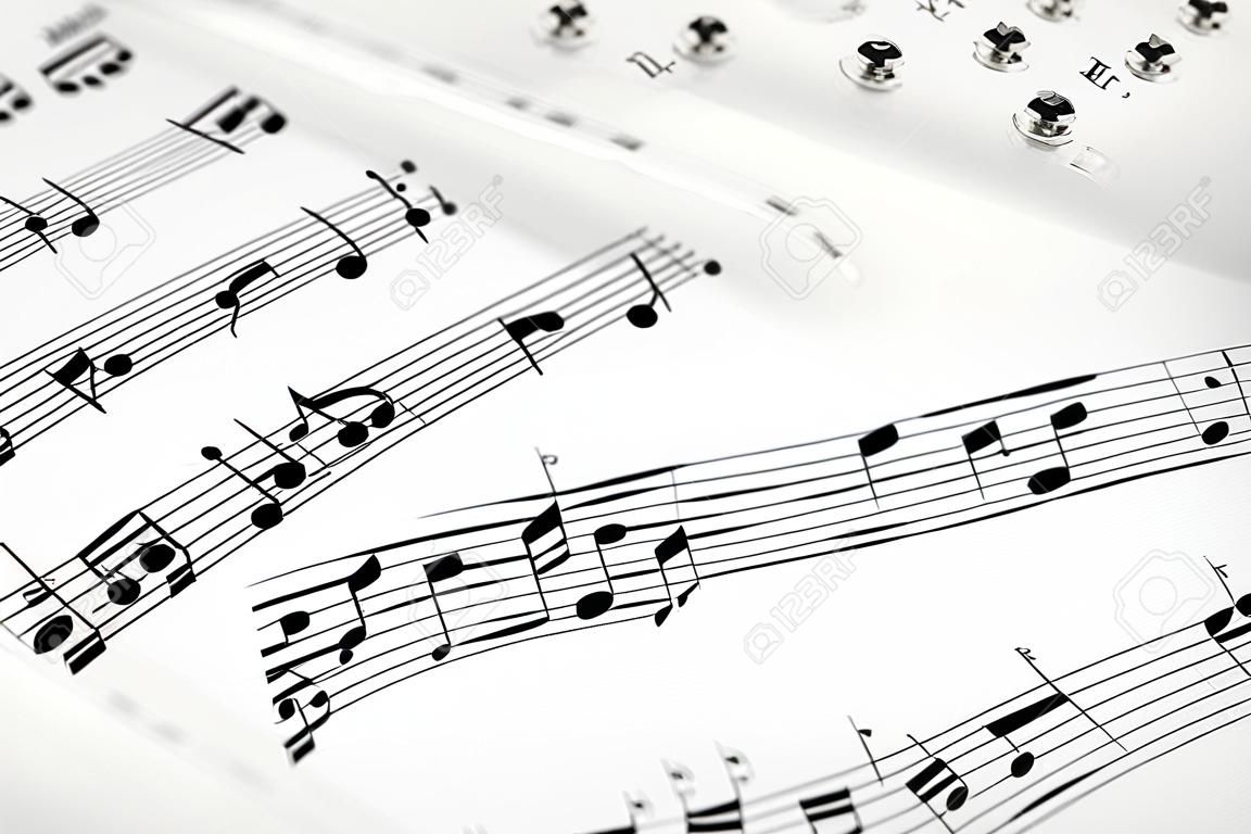 Musikalisches Konzept Hintergrund: Makro-Ansicht der weißen Notenblatt Musik mit Noten mit selektiven Fokus-Effekt