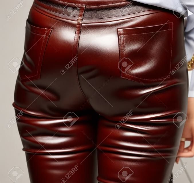 Leather pants on the legs of the girl .