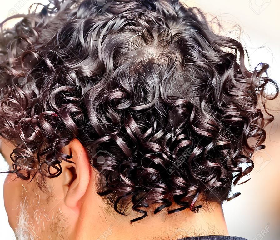 Black curly hair on the head of a man. close-up