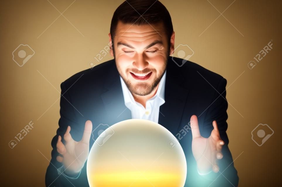 Un hombre de negocios, mirando hacia el futuro en una bola de cristal