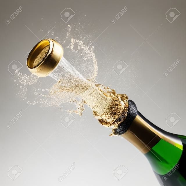 Champagne bottle popping on a white background