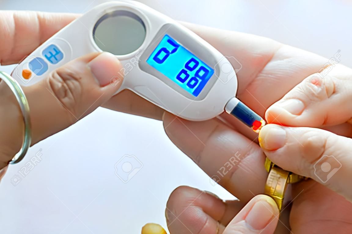 hand of people check diabetes and high blood glucose monitor with digital pressure gauge. Healthcare and Medical concept