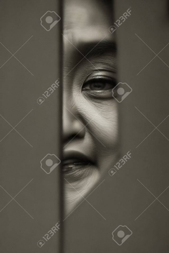 ernstig portret van half gezicht van Aziatische vrouw zwart en wit