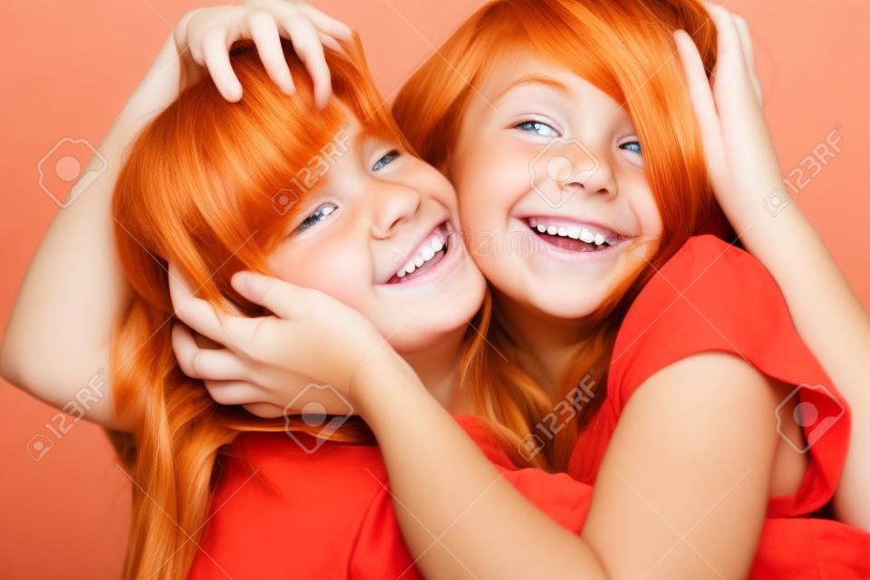 roten und blonden Mädchen tousle Haar mit den Händen und lächeln
