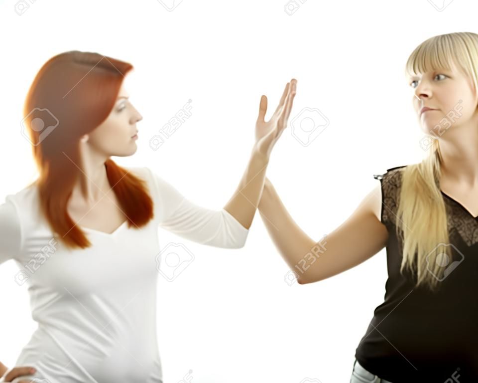 young beautiful red and blond haired girls stop it in front of white background