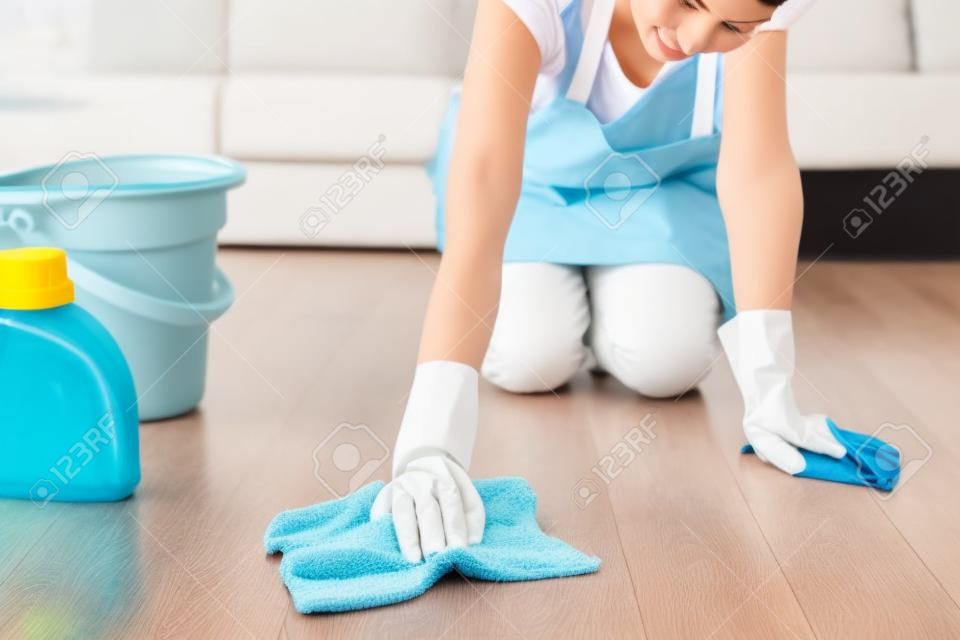 Vrouw met doek schoonmaken vloer in huis