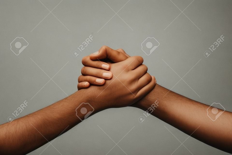 Two hands holding each other strongly