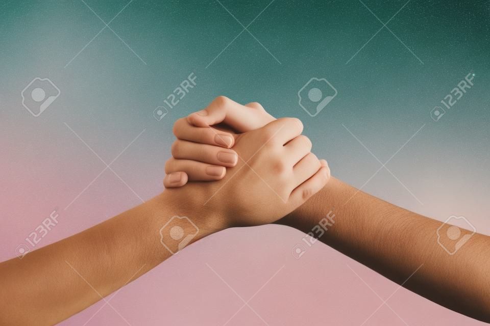 Two hands holding each other strongly