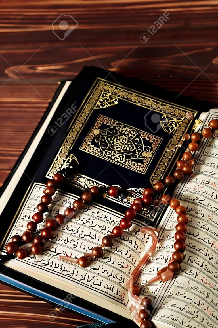 Islamitische Heilige Boek koran met rozenkrans kralen op houten tafel achtergrond. Kuran het heilige boek os moslims. Ramadan concept.