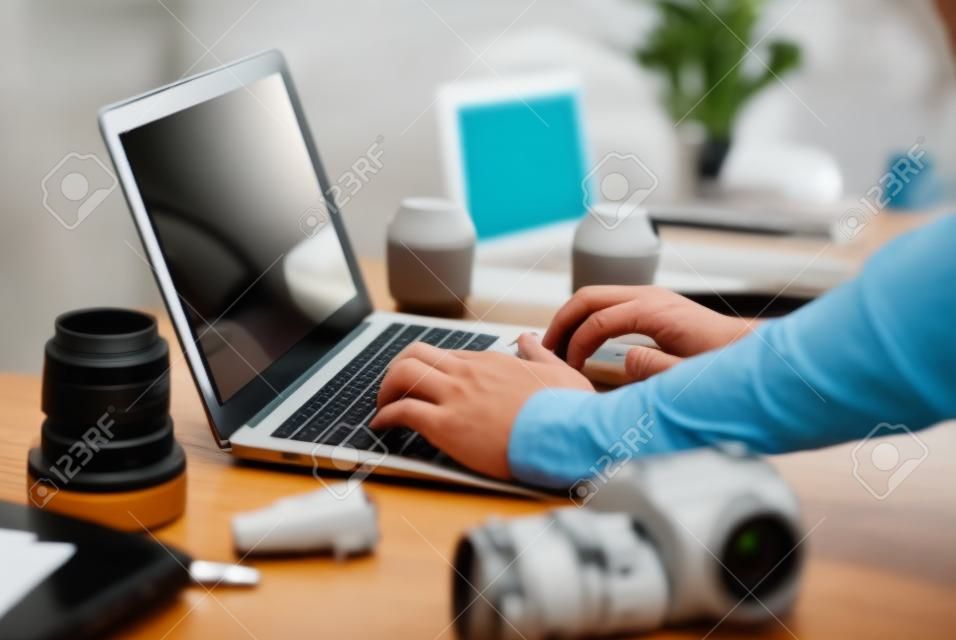 Photographe travaillant avec un ordinateur portable au bureau