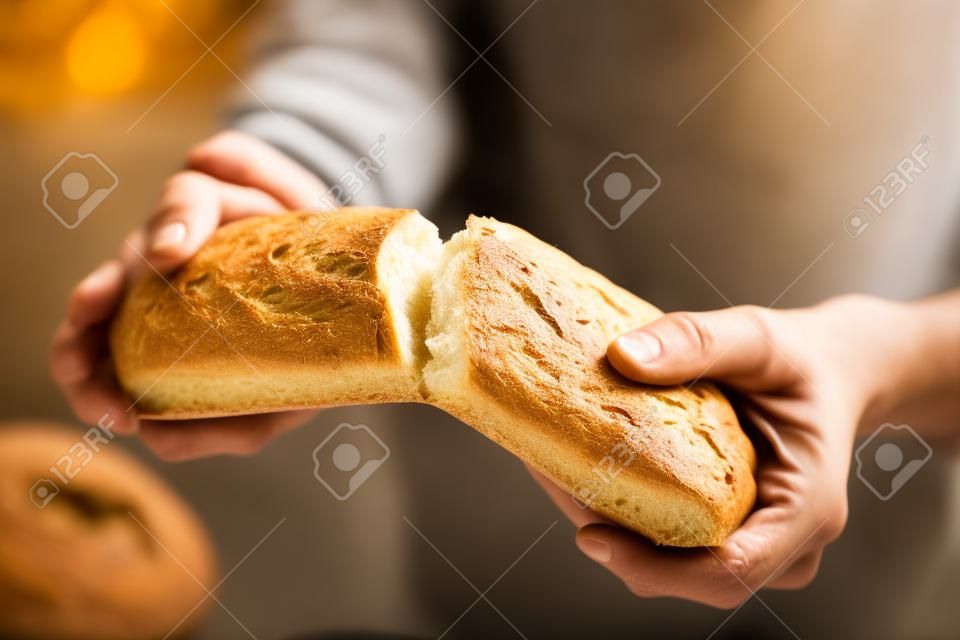 Il maschio passa la rottura del pane appena sfornato, primo piano