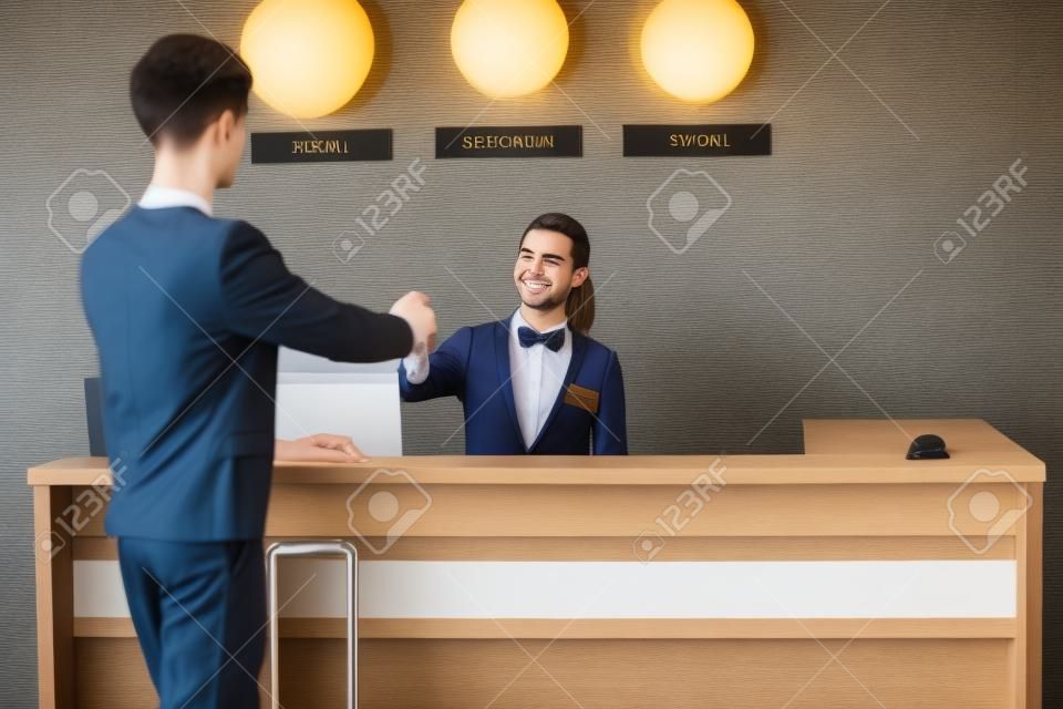 Young man at reception desk in hotel