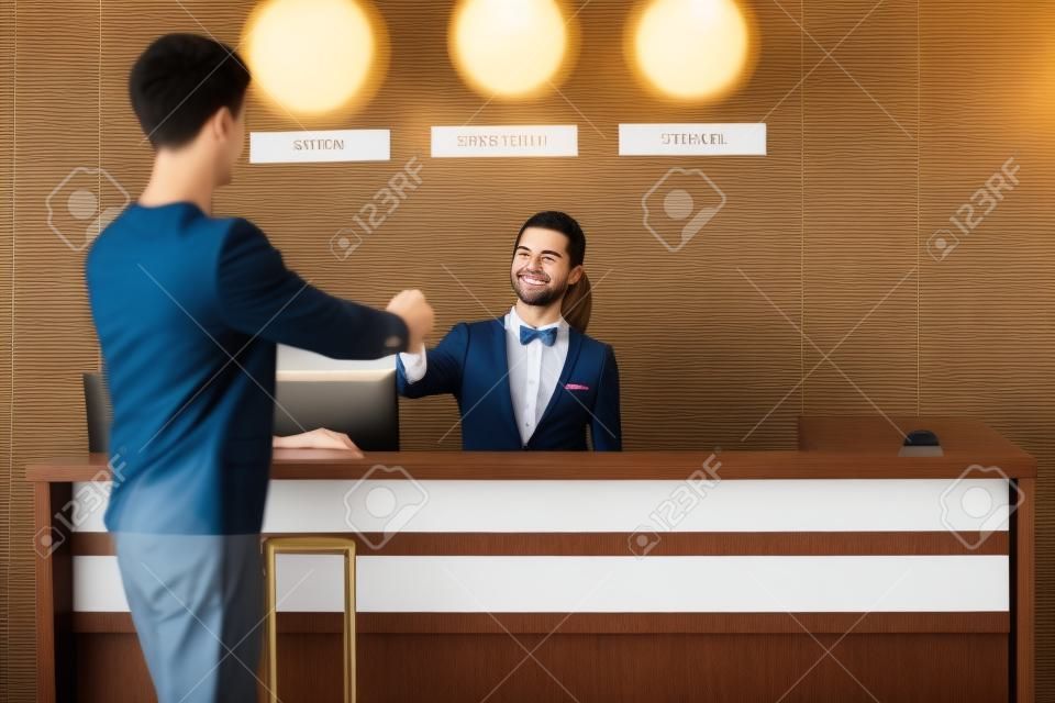 Young man at reception desk in hotel