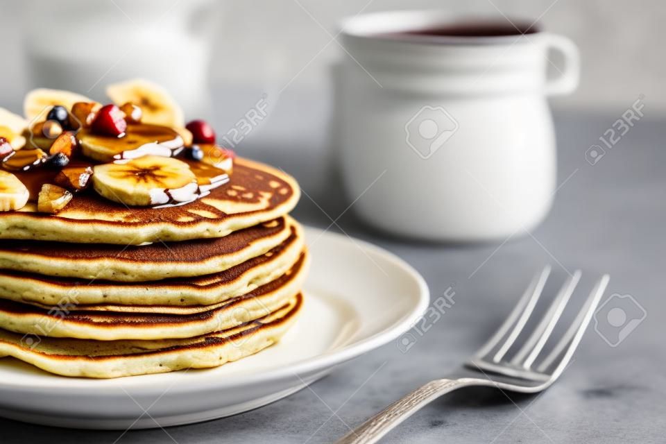 Plate with yummy banana pancakes on table