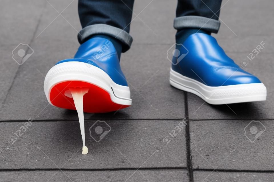 Foot stuck into chewing gum on street. Concept of stickiness