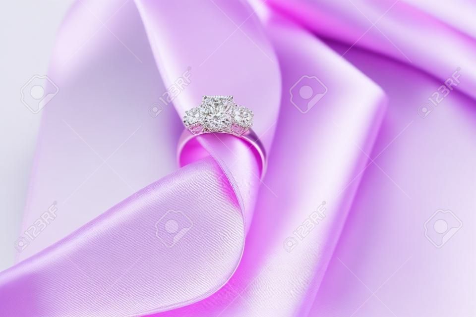 Ribbon with beautiful engagement ring on table