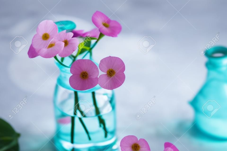 Glass bottle with flowers on table