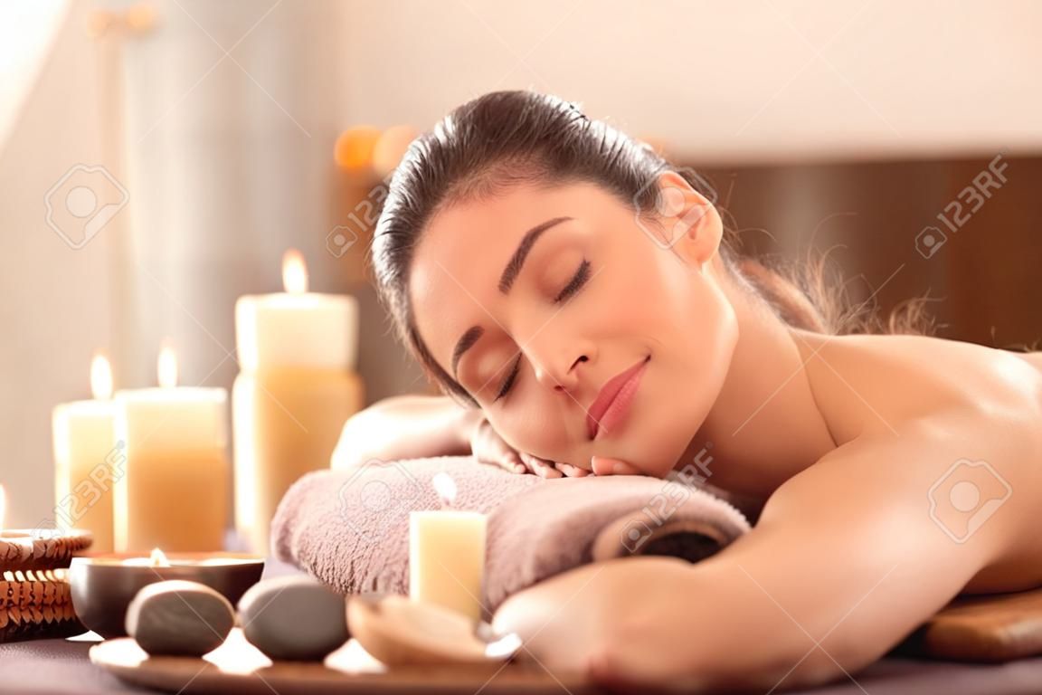 Młoda kobieta relaksująca się na stole do masażu w salonie spa