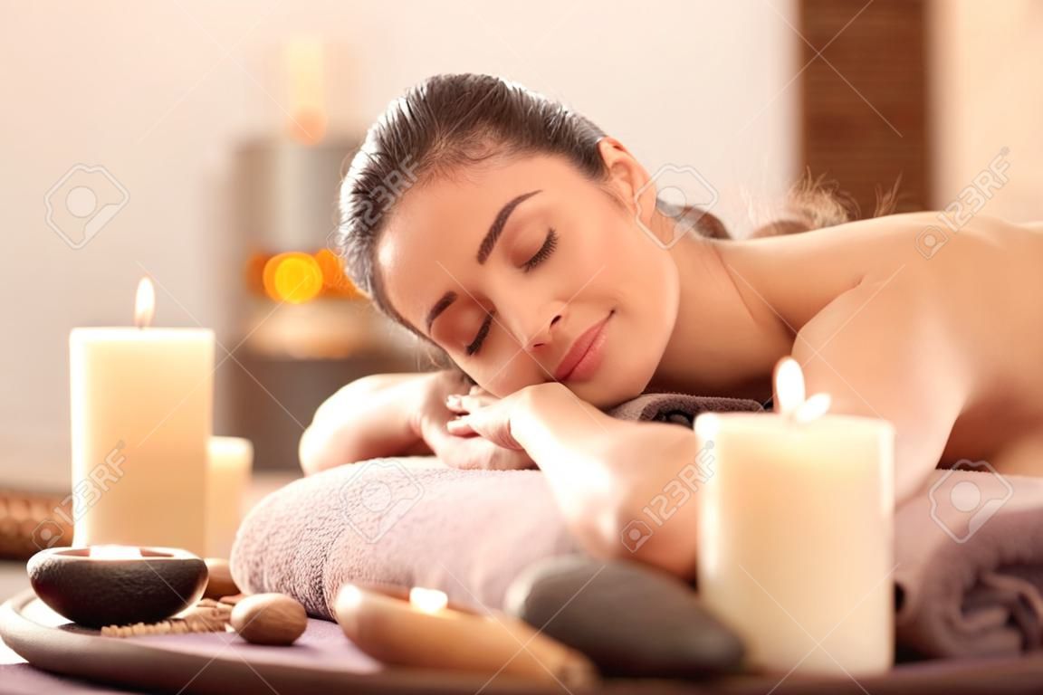 Młoda kobieta relaksująca się na stole do masażu w salonie spa