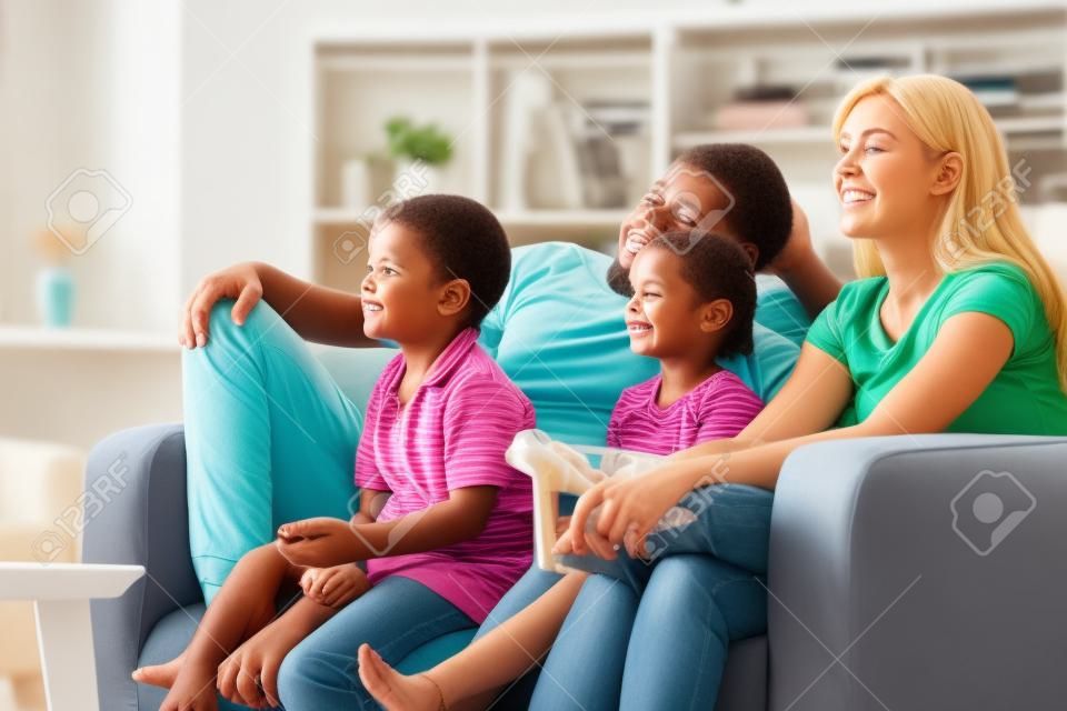 Familia viendo la televisión en el sofá en casa