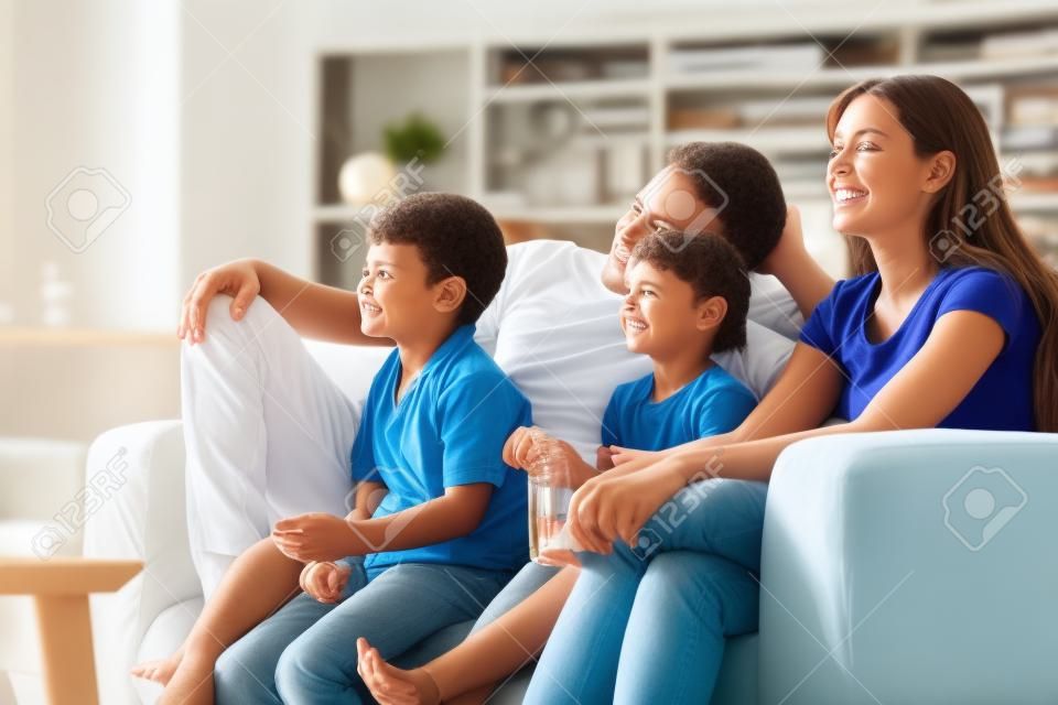 Familia viendo la televisión en el sofá en casa