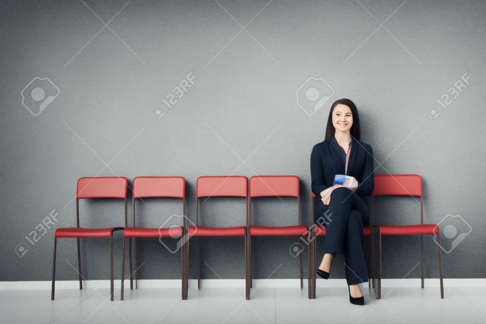 Młoda kobieta czeka na rozmowę kwalifikacyjną w pomieszczeniu