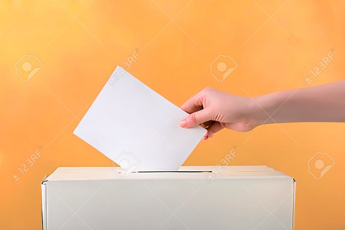 Femme votante près de l'urne sur fond de couleur