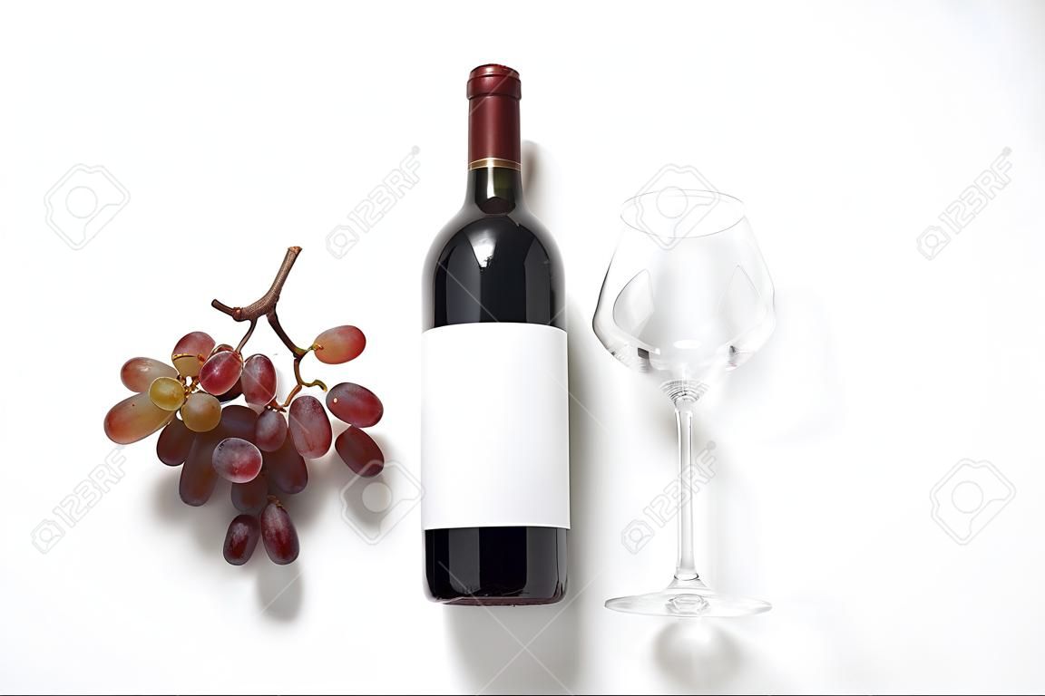 Bottiglia di vino con etichetta vuota, vetro e uva su sfondo bianco