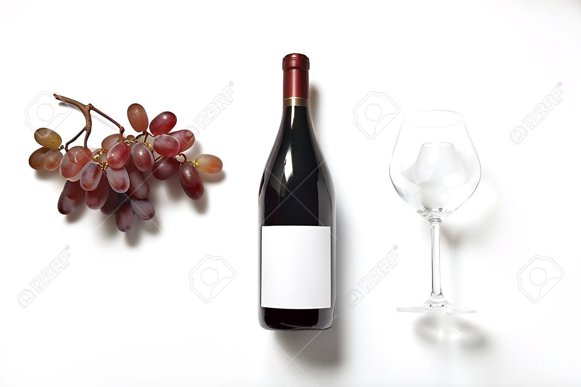 Flasche Wein mit leerem Etikett, Glas und Trauben auf weißem Hintergrund