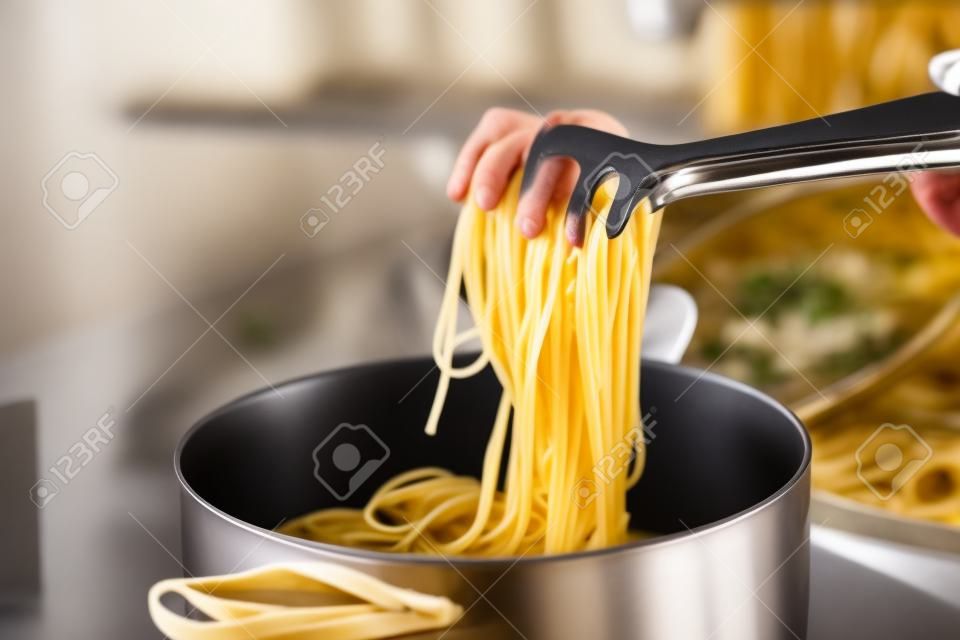 Cooking pot with pasta on electric stove in kitchen