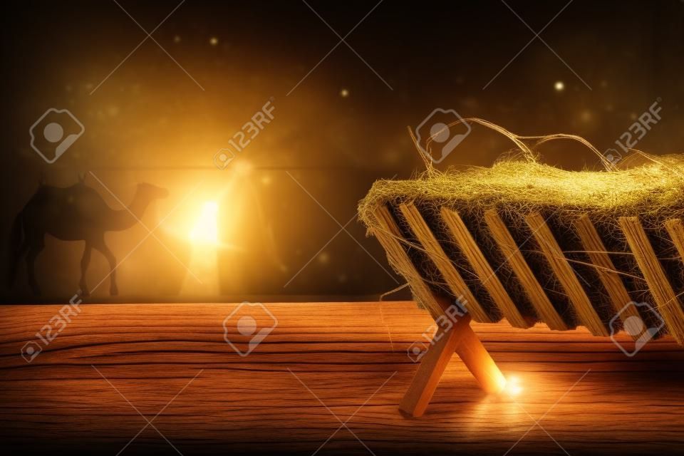 Drewniany żłóbek z sianem na stole w nocy. koncepcja świątecznej historii