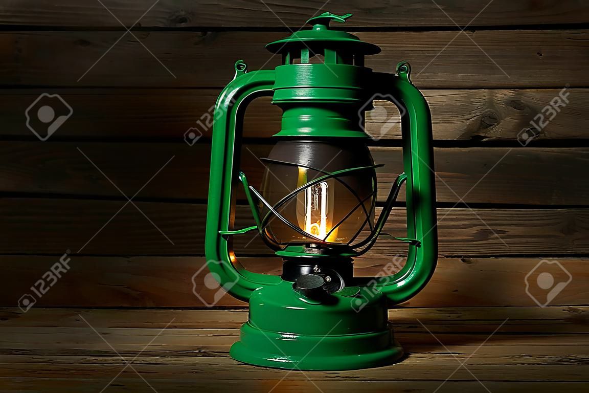 Lámpara retro verde sobre fondo de madera