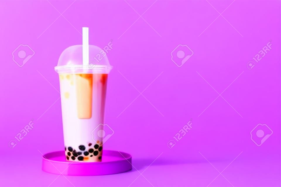 Plastic cup of tasty bubble tea on purple background