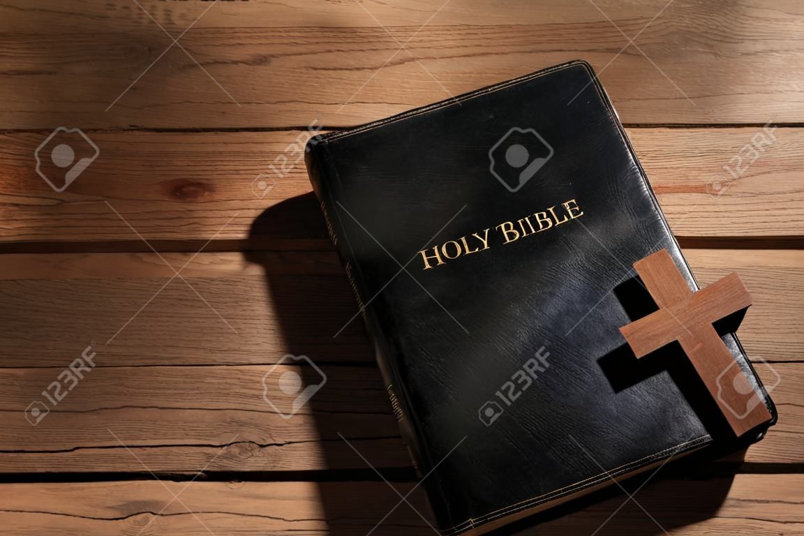 Holy Bible with cross on wooden background