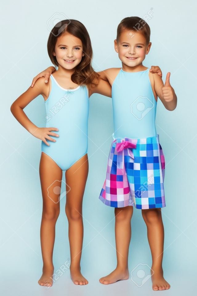 Ein Porträt von zwei Kindern in Badeanzügen auf dem weißen Hintergrund