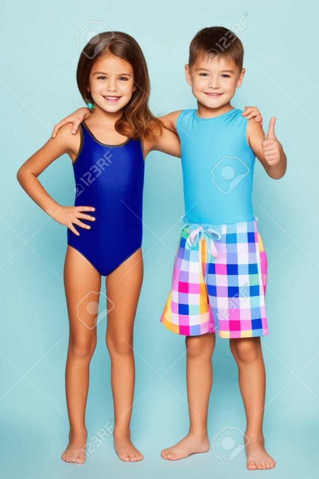 Portret dwojga dzieci w strojach kąpielowych na białym tle