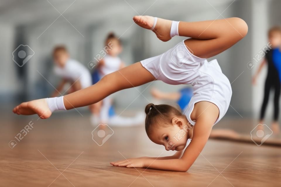 Dzieci w sport-młoda gimnastyczka trenować swoje ciało