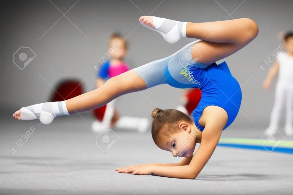 Niños en gimnasta deportivo jóvenes entrenan su cuerpo