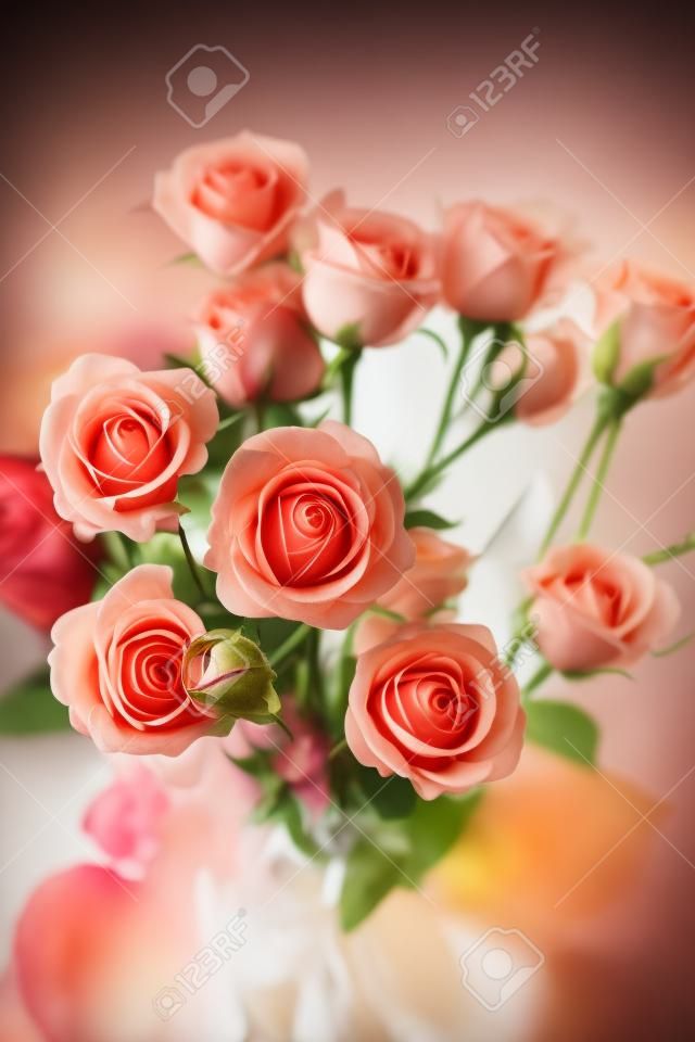 Beautiful bouquet of peach roses in vintage vase on a black background