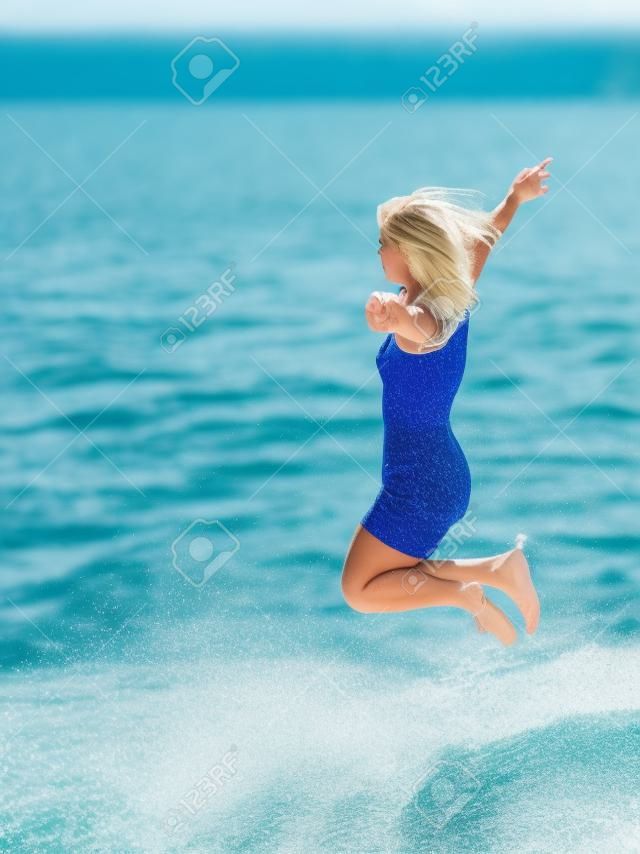 Blonde girl jumping into the water