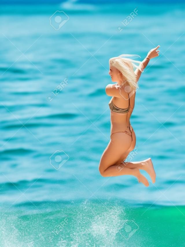 Blonde girl jumping into the water