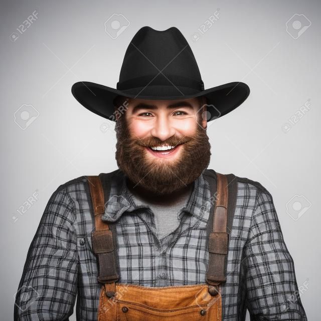 快樂的微笑鬍子的農民在白色背景上孤立的帽子