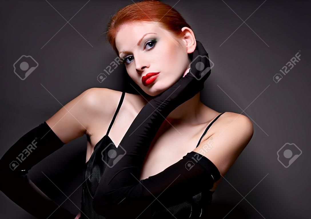 Portrait of attractive redhead model on dark background