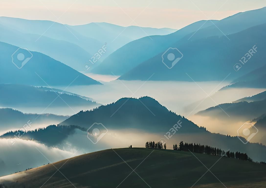 山のシルエット。カルパチア山脈の秋の朝。霧の夜明け