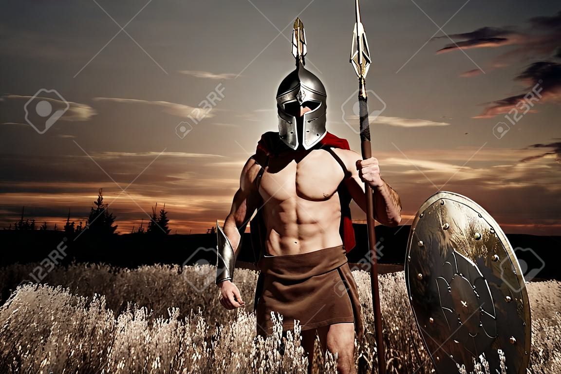Soldat wie spartanisch im Sturzhelm, der gerundeten Schild hält.