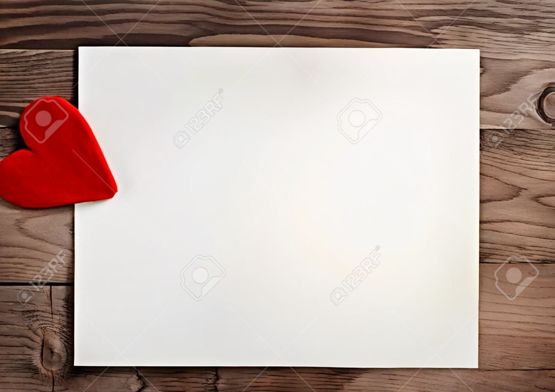 Grußkarte mit einem roten Herzen und Platz für Text auf Holzuntergrund