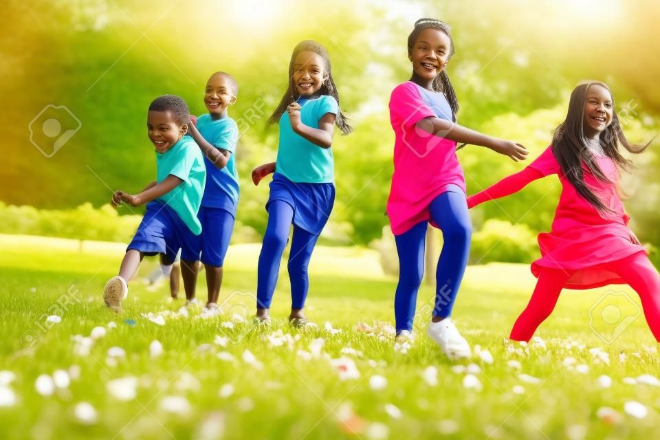 Cinco feliz diversidade procurando crianças correndo no parque