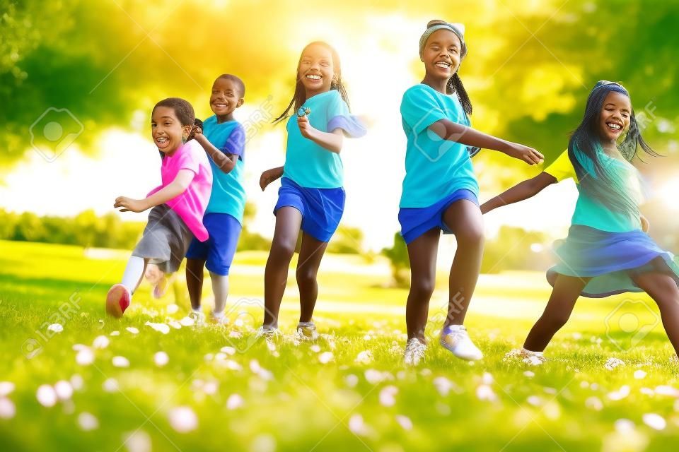 Pięć szczęśliwych dzieci różnorodność patrząc uruchomione w parku