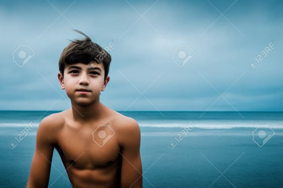 海景に対してひどい表情をした10代の少年