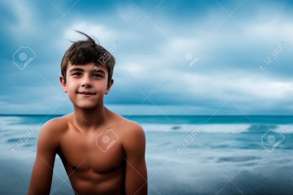 Teenage boy with wistful look against seascape